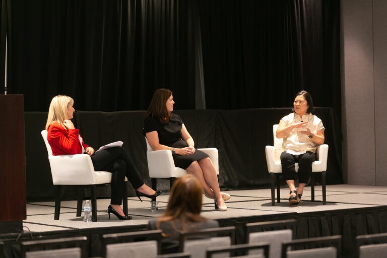 CREW Network three females in discussion on stage